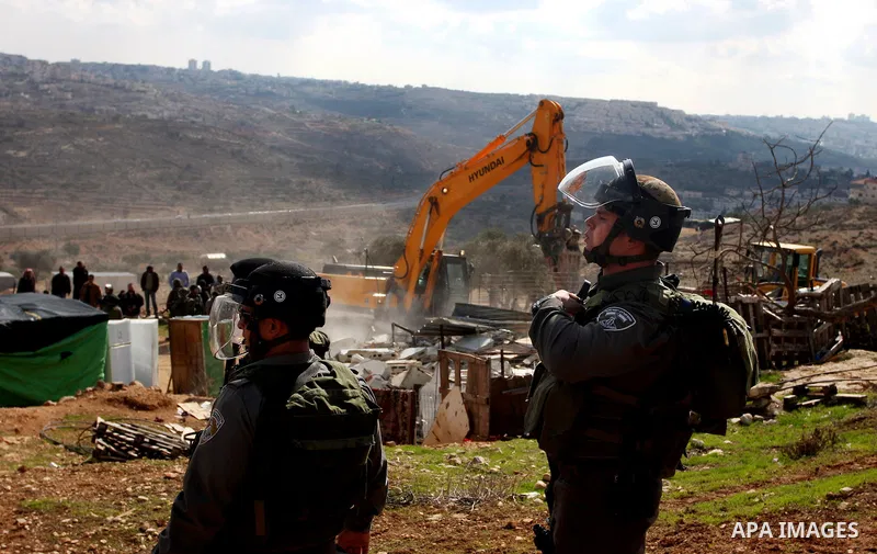 Palestinians from the Bedouin Abu Mansor family stand as Israeli forces destroy his family house in an area of the east Jerusalem neighborhood of Beit Hanina which falls in the West Bank side of Israel's separation barri...