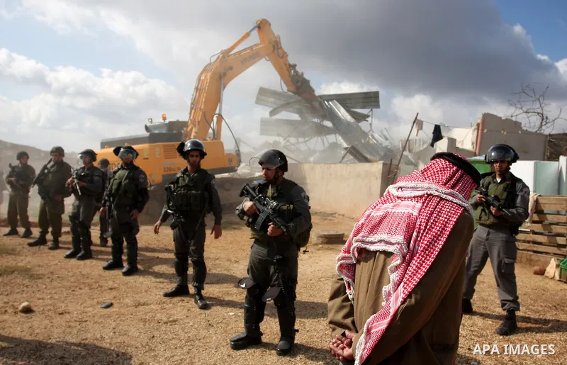 A Palestinian man from the Bedouin Abu Mansor family stands as Israeli forces destroy his family house in an area of the east Jerusalem neighborhood of Beit Hanina which falls in the West Bank side of Israel's separation...