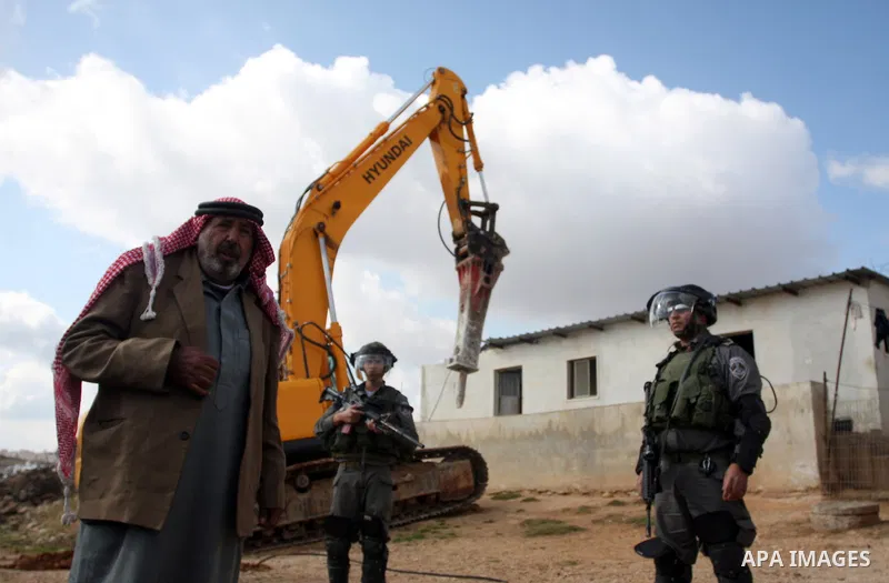 A Palestinian man from the Bedouin Abu Mansor family stands as Israeli forces destroy his family house in an area of the east Jerusalem neighborhood of Beit Hanina which falls in the West Bank side of Israel's separation...