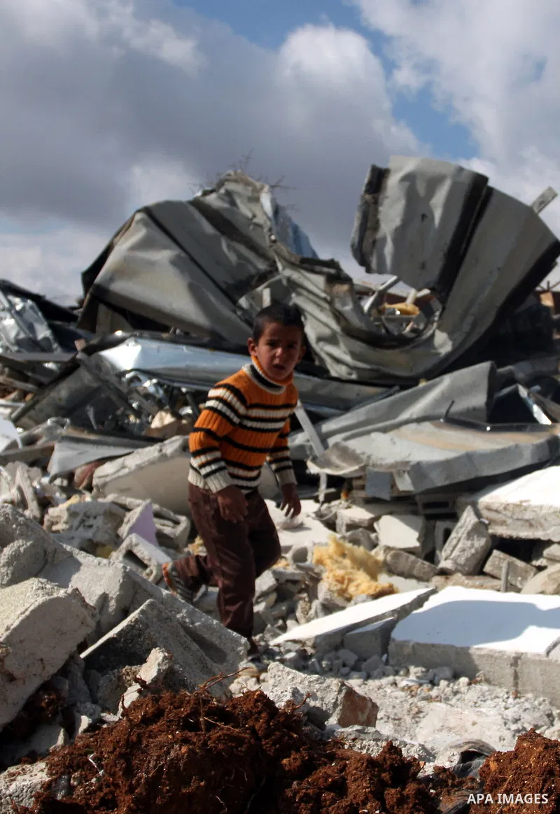 Palestinians from the Bedouin Abu Mansor family stand on the rubble after Israeli forces destroyed their family house in an area of the east Jerusalem neighborhood of Beit Hanina which falls in the West Bank side of Isra...