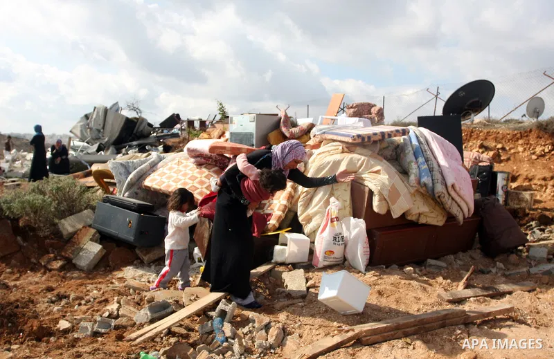 Palestinians from the Bedouin Abu Mansor family stand on the rubble after Israeli forces destroyed their family house in an area of the east Jerusalem neighborhood of Beit Hanina which falls in the West Bank side of Isra...