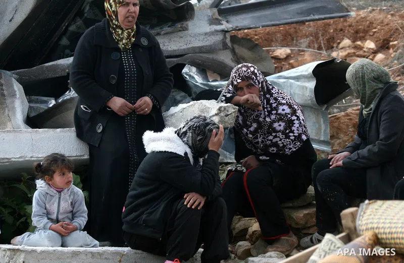 Palestinians from the Bedouin Abu Mansor family stand on the rubble after Israeli forces destroyed their family house in an area of the east Jerusalem neighborhood of Beit Hanina which falls in the West Bank side of Isra...
