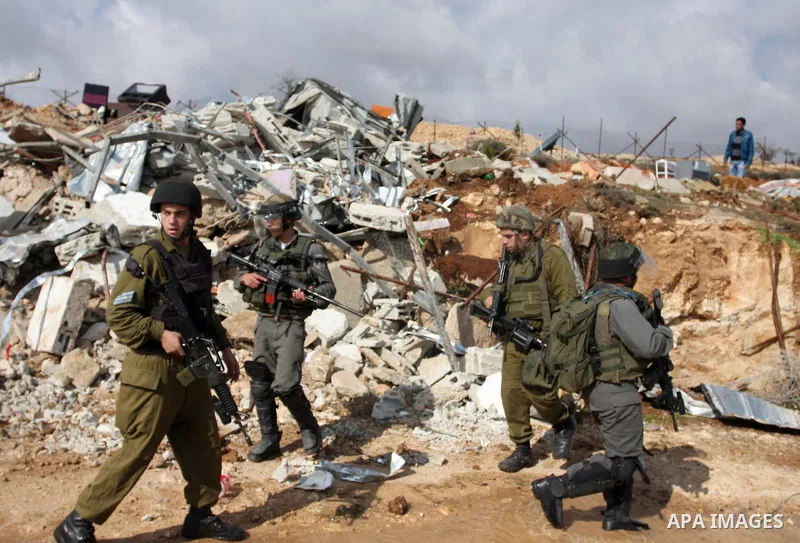 Palestinians from the Bedouin Abu Mansor family stand as Israeli forces destroy his family house in an area of the east Jerusalem neighborhood of Beit Hanina which falls in the West Bank side of Israel's separation barri...