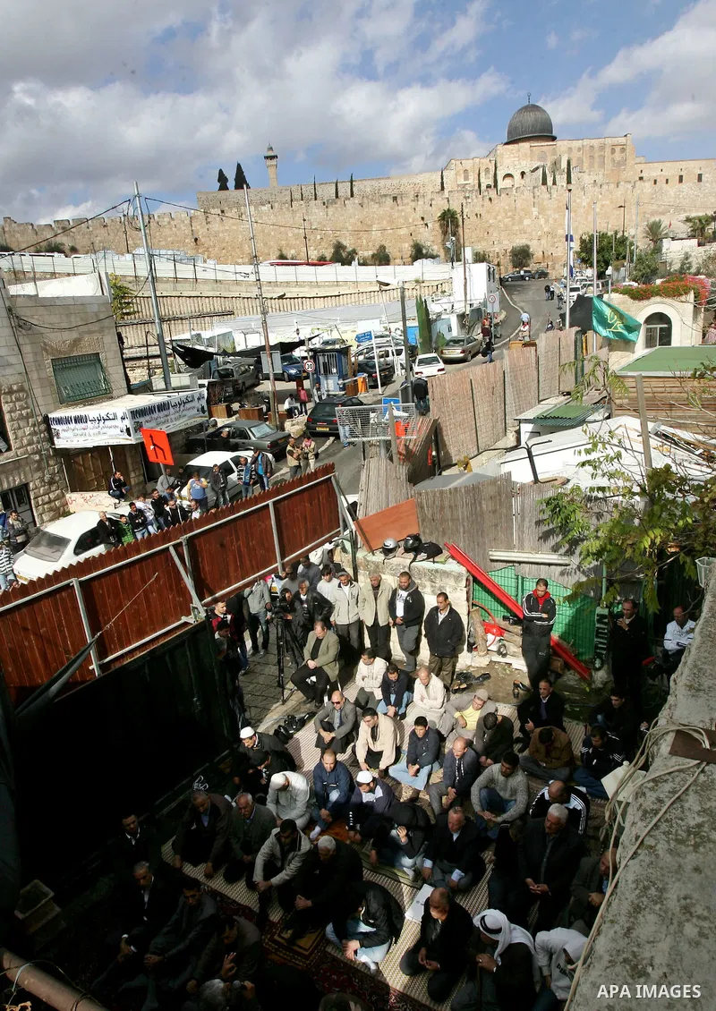 Palestinians attend Friday prayers inside the house of Samarin family which the Israeli authorities threatened to size it in Jerusalem's neighbourhood of Silwan on Nov. 25,2011. Photo by Mahfouz Abu Turk