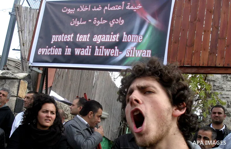 Palestinians and foreigners take part in a protest near the house of Samarin family which the Israeli authorities threatened to size it in Jerusalem's neighbourhood of Silwan on Nov. 25,2011. Photo by Mahfouz Abu Turk