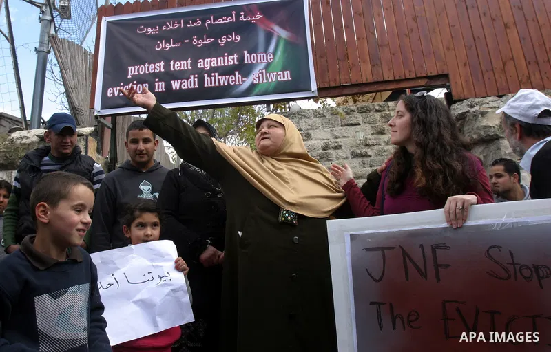 Palestinians and foreigners take part in a protest near the house of Samarin family which the Israeli authorities threatened to size it in Jerusalem's neighbourhood of Silwan on Nov. 25,2011. Photo by Mahfouz Abu Turk