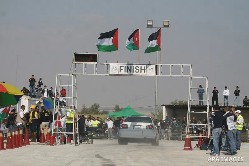 A driver competes with his car during a car rally in the West Bank city of Jericho November 25, 2011. Some 50 drivers from the Palestinian Territories and Jordan competed on Friday in the final round of the Palestinian c...