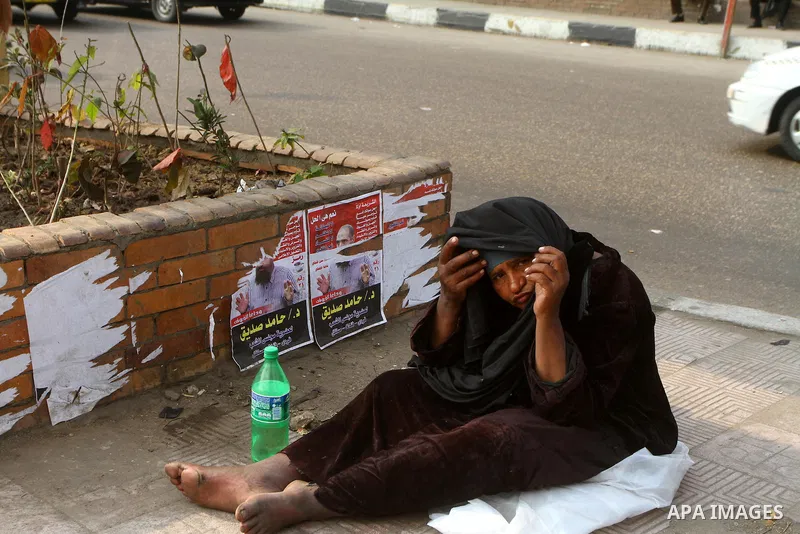 Egyptians walk past electoral campaign banners in Cairo on November 26, 2011 ahead of a three-round parliamentary election. The parliamentary elections that get underway on November 28 will be the first polls since a pop...