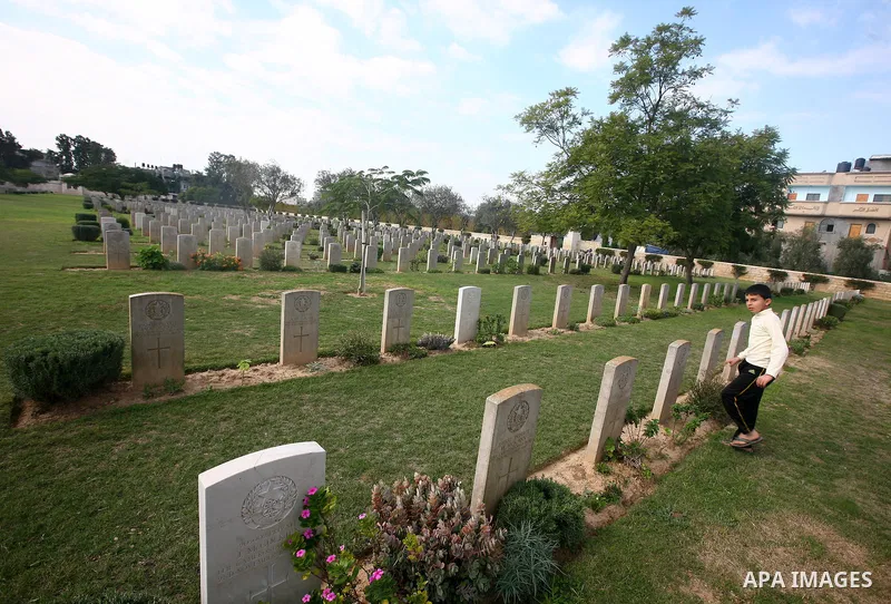 Palestinian children are seen in the British cemetery in Gaza City on Nov 26, 2011. Israel said it would compensate British for damages that hit the British cemetery during the war on Gaza. Photo by Majdi Fathi