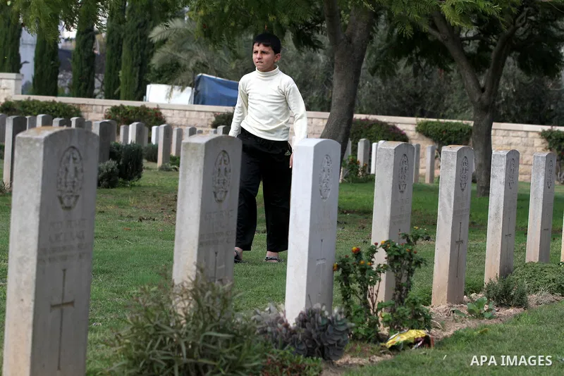 Palestinian children are seen in the British cemetery in Gaza City on Nov 26, 2011. Israel said it would compensate British for damages that hit the British cemetery during the war on Gaza. Photo by Majdi Fathi