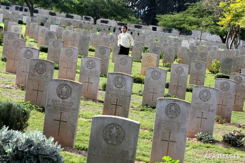 Palestinian children are seen in the British cemetery in Gaza City on Nov 26, 2011. Israel said it would compensate British for damages that hit the British cemetery during the war on Gaza. Photo by Majdi Fathi