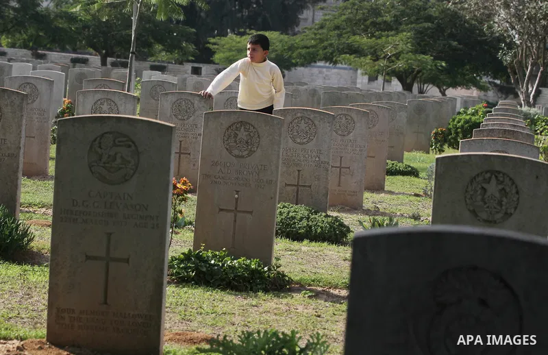 Palestinian children are seen in the British cemetery in Gaza City on Nov 26, 2011. Israel said it would compensate British for damages that hit the British cemetery during the war on Gaza. Photo by Majdi Fathi