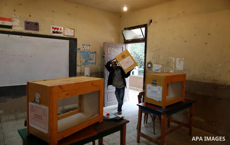 An Egyptian man carries an electoral box into a polling station at a school in Cairo on November 27, 2011 on the eve of the first parliament elections since the end of the 30-year rule of strongman Hosni Mubarak. Photo b...