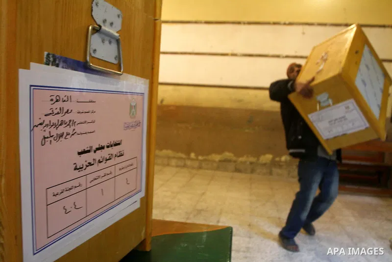 An Egyptian man carries an electoral box into a polling station at a school in Cairo on November 27, 2011 on the eve of the first parliament elections since the end of the 30-year rule of strongman Hosni Mubarak. Photo b...