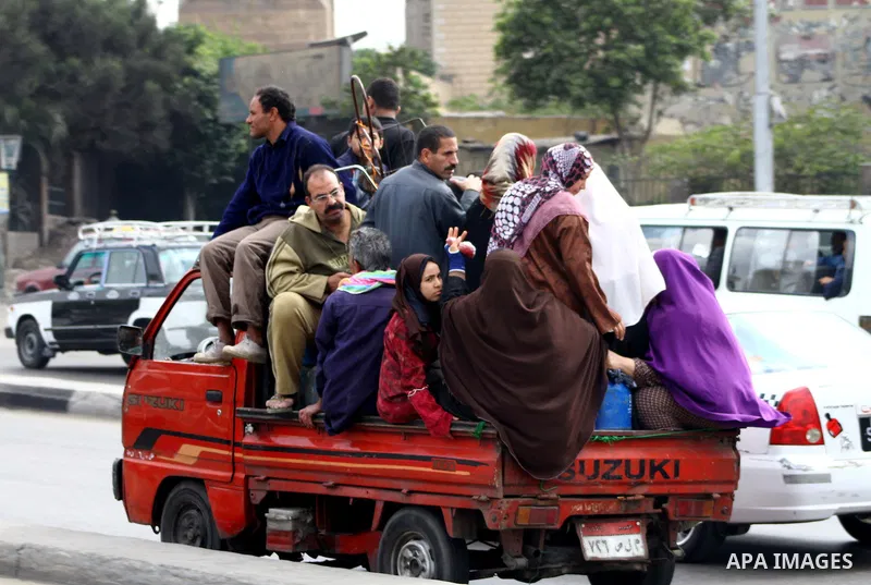 Egyptians ride a van at a street in Cairo on November 27, 2011 on the eve of the first parliament elections since the end of the 30-year rule of strongman Hosni Mubarak. Photo by Ashraf Amra