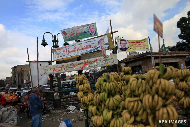 An Egyptian fruit vendor waits for customers under electoral campaign banners in Cairo on November 27, 2011 on the eve of the first parliament elections since the end of the 30-year rule of strongman Hosni Mubarak. Photo...