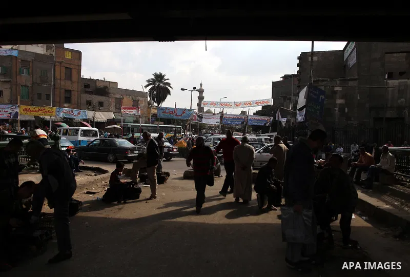 Egyptians walk beneath elections campaign banners and posters in Cairo on November 27, 2011 on the eve of the first parliament elections since the end of the 30-year rule of strongman Hosni Mubarak. Photo by Wissam Nassa...