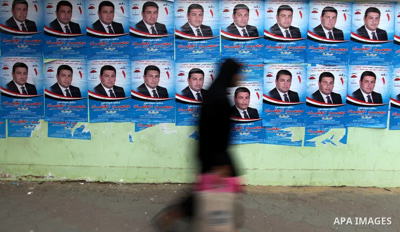 An Egyptian walks past electoral campaign posters and banners for candidates in Cairo on November 27, 2011 on the eve of the first parliament elections since the end of the 30-year rule of strongman Hosni Mubarak. Photo...