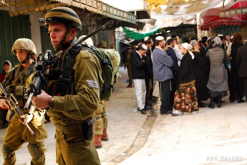 Israeli soldiers block a narrow street in the old quarter of the Israeli occupied West Bank city of Hebron, on November 26, 2011, to allow Jewish settlers and other Israelis to tour the Palestinian area of the old city a...