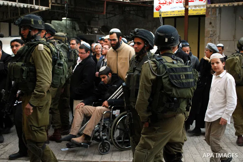 Israeli soldiers block a narrow street in the old quarter of the Israeli occupied West Bank city of Hebron, on November 26, 2011, to allow Jewish settlers and other Israelis to tour the Palestinian area of the old city a...