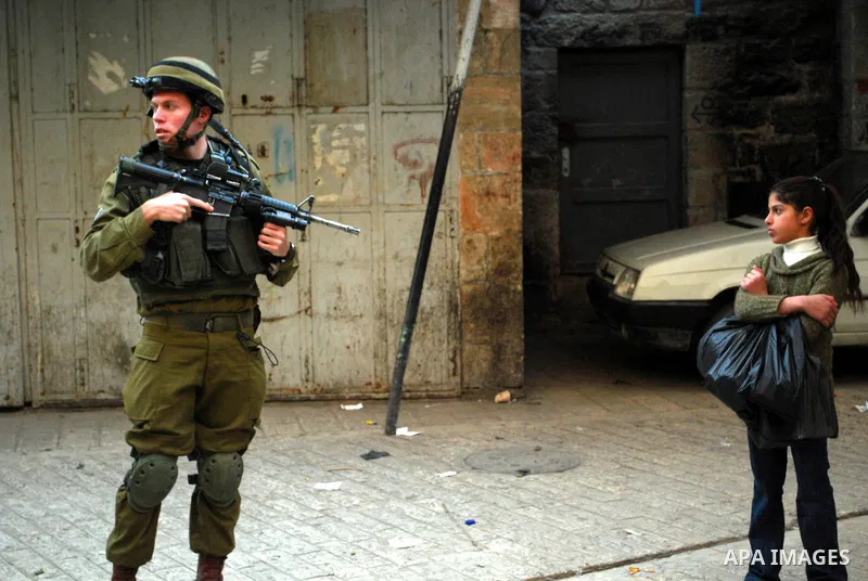 Israeli soldiers block a narrow street in the old quarter of the Israeli occupied West Bank city of Hebron, on November 26, 2011, to allow Jewish settlers and other Israelis to tour the Palestinian area of the old city a...