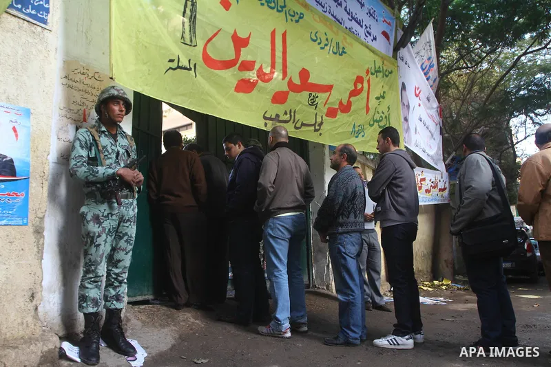 An Egyptian soldier stands guard as voters queue at a polling station in the Manial neighbourhood of Cairo on November 28, 2011. Egyptians began voting in the first elections since the fall of autocrat Hosni Mubarak who...