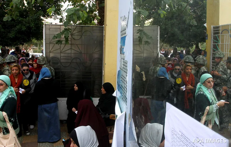 Egyptian soldiers stand guard as voters queue outside a school turned polling station in Cairo on November 28, 2011. Egyptians began voting in the first elections since the fall of autocrat Hosni Mubarak who was ousted i...