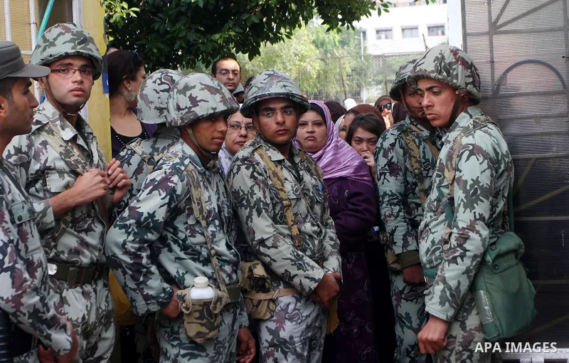 Egyptian soldiers stand guard as voters queue outside a school turned polling station in Cairo on November 28, 2011. Egyptians began voting in the first elections since the fall of autocrat Hosni Mubarak who was ousted i...