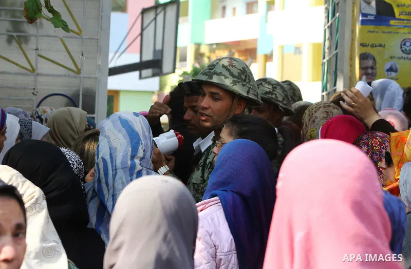 Egyptian soldiers stand guard as voters queue outside a school turned polling station in Cairo on November 28, 2011. Egyptians began voting in the first elections since the fall of autocrat Hosni Mubarak who was ousted i...