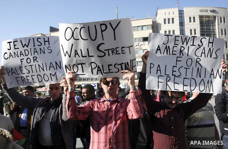 Palestinian and foreign peace activists hold placards during a gathering to mark the International Day of Solidarity with the Palestinian People, on November 29, 2011 in the West Bank city of Nablus. Photo by Wagdi Eshta...