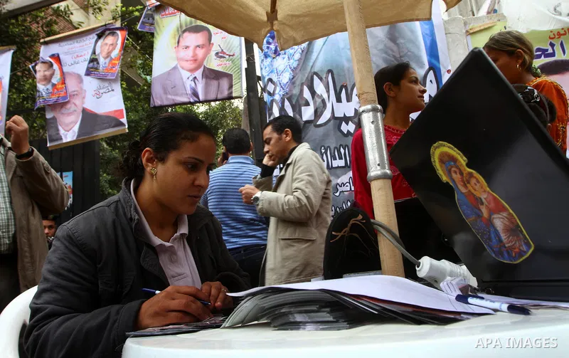 Egyptian volunteers help women find their polling station in Cairo, Egypt, on November 29, 2011. Egypt hailed the start of its first post-revolution election as a triumph for democracy as more voters headed to the polls,...