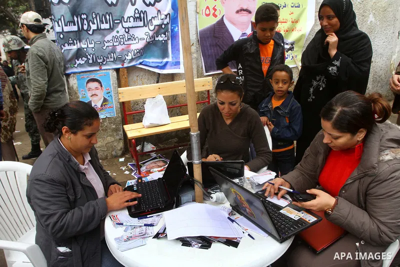 Egyptian volunteers help women find their polling station in Cairo, Egypt, on November 29, 2011. Egypt hailed the start of its first post-revolution election as a triumph for democracy as more voters headed to the polls,...