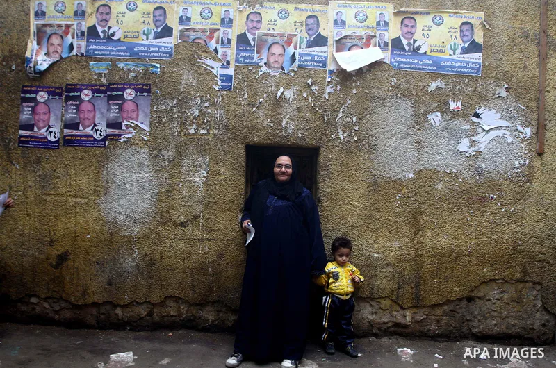 Egyptians stand outside their house in Cairo on November 29, 2011. Egypt hailed the start of its first post-revolution election as a triumph for democracy as more voters headed to the polls, boosting turn-out for a vote...