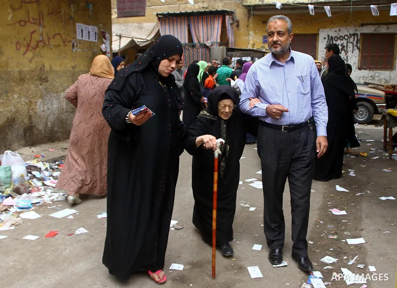 Egyptians walk outside their house in Cairo on November 29, 2011. Egypt hailed the start of its first post-revolution election as a triumph for democracy as more voters headed to the polls, boosting turn-out for a vote t...