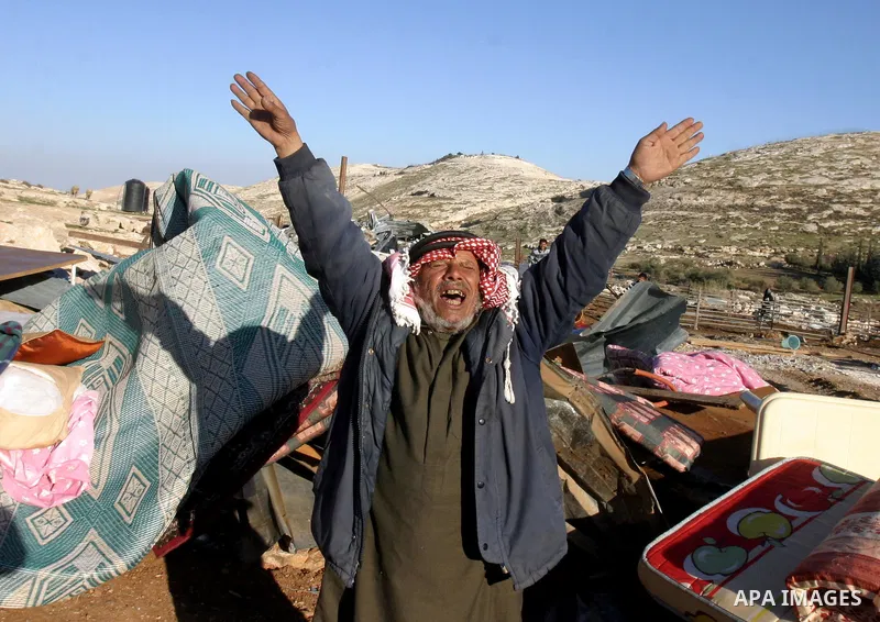 Palestinian Bedouin man reacts amidst the rubble of a structure after it was razed by the Israeli army in the West Bank village of Zayem, near Jerusalem November 29, 2011. According to Israeli authorities the structures...