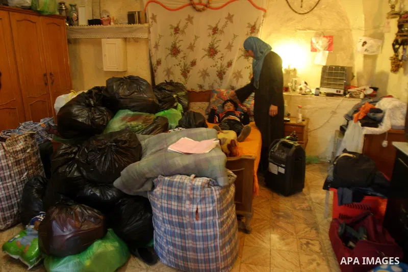 Palestinian members of Abu Diab family stand next their belongings at their house in Wadi Helwa, in Jerusalem's neighbourhood of Silwan on Nov. 30,2011. Abu Diab family received a notification from a lawyer for Jewish se...