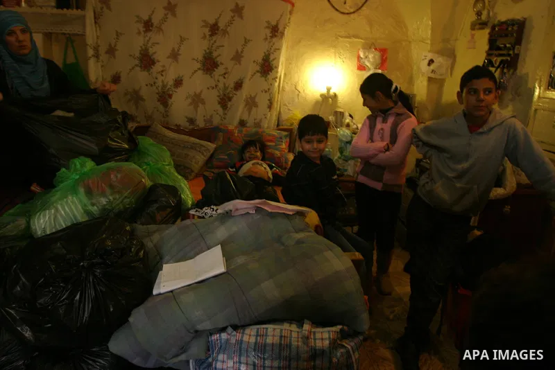 Palestinian members of Abu Diab family stand next their belongings at their house in Wadi Helwa, in Jerusalem's neighbourhood of Silwan on Nov. 30,2011. Abu Diab family received a notification from a lawyer for Jewish se...