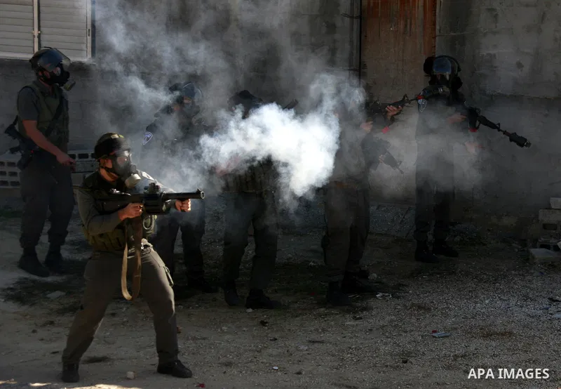 Israeli border police officers fire tear gas towards Palestinian demonstrators, not seen, during a protest in the village of Kufr Qaddum near the Israeli settlement of Kdumim, in the northern West Bank, Friday, Dec. 2, 2...