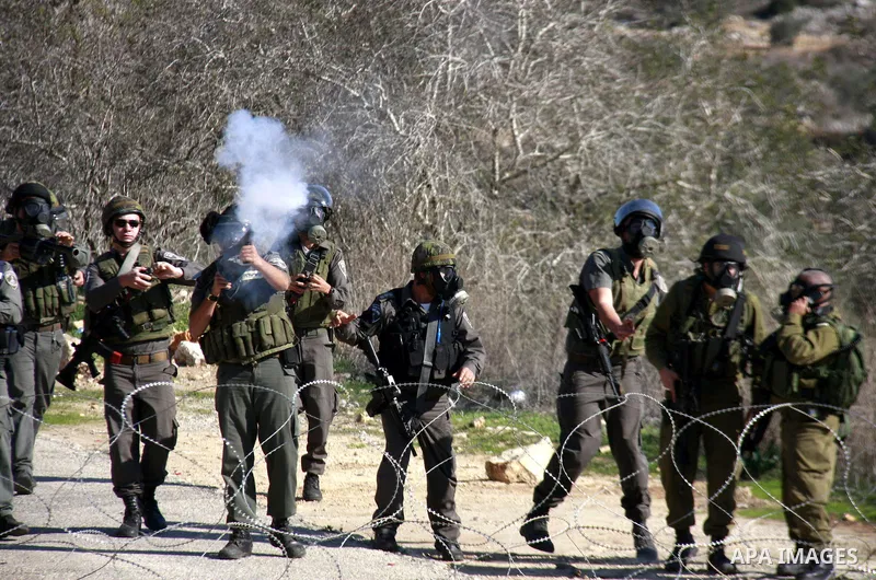 Israeli border police officers fire tear gas towards Palestinian demonstrators, not seen, during a protest in the village of Kufr Qaddum near the Israeli settlement of Kdumim, in the northern West Bank, Friday, Dec. 2, 2...