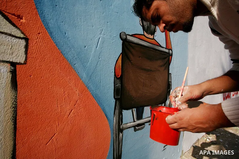 Palestinian Artists take part in paint a murals to mark the International Day for Persons with Disabilities on Dec. 03, 2011 in Gaza City.Photo by Mahmud Nassar