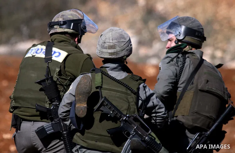 A Palestinian man is carried by Israeli border police officers after he tried to block a construction vehicle from working on Israel's barrier in the West Bank village of Qaladiya near Ramallah December 4, 2011. Accordin...