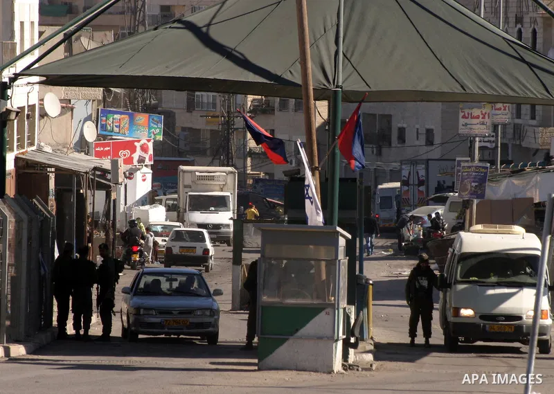 Palestinians are checked by Israeli soldiers at a checkpoint in the east Jerusalem refugee camp of Shuafat on Dec. 4,2011. Photo by Mahfouz Abu Turk