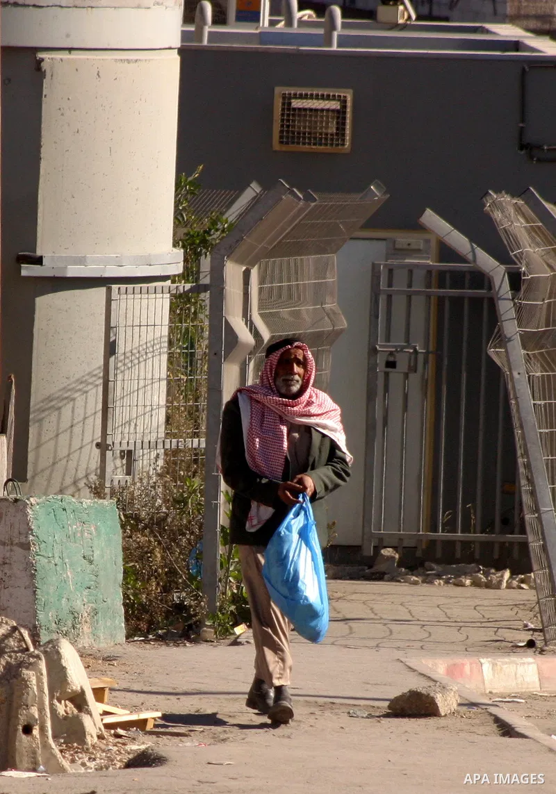 Palestinians cross through an Israeli checkpoint in the east Jerusalem refugee camp of Shuafat on Dec. 4,2011. Photo by Mahfouz Abu Turk