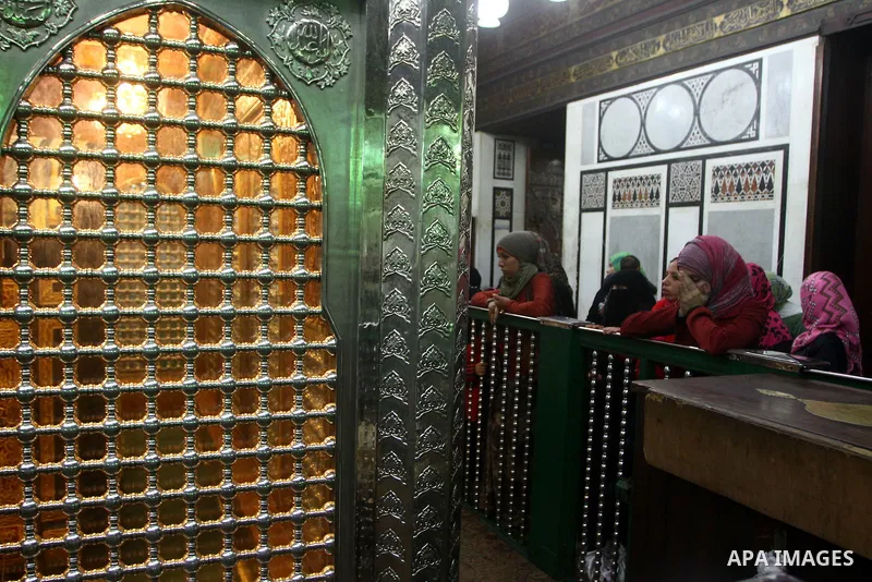 Egyptian Muslims pray at a tomb in al-Hussein mosque, which according to the belief head of Imam Hussein, the grandson of prophet Mohammed, is buried, in the old city of Cairo on December 4, 2011. Photo by Ashraf Amra