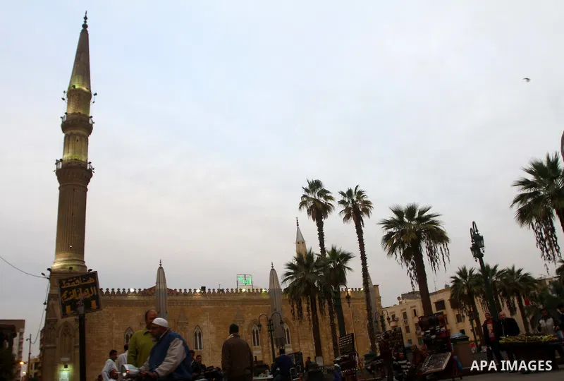 Tourists walk outside the al-Hussein mosque, which according to the belief head of Imam Hussein, the grandson of prophet Mohammed, is buried, in the old city of Cairo on December 4, 2011. Photo by Ashraf Amra