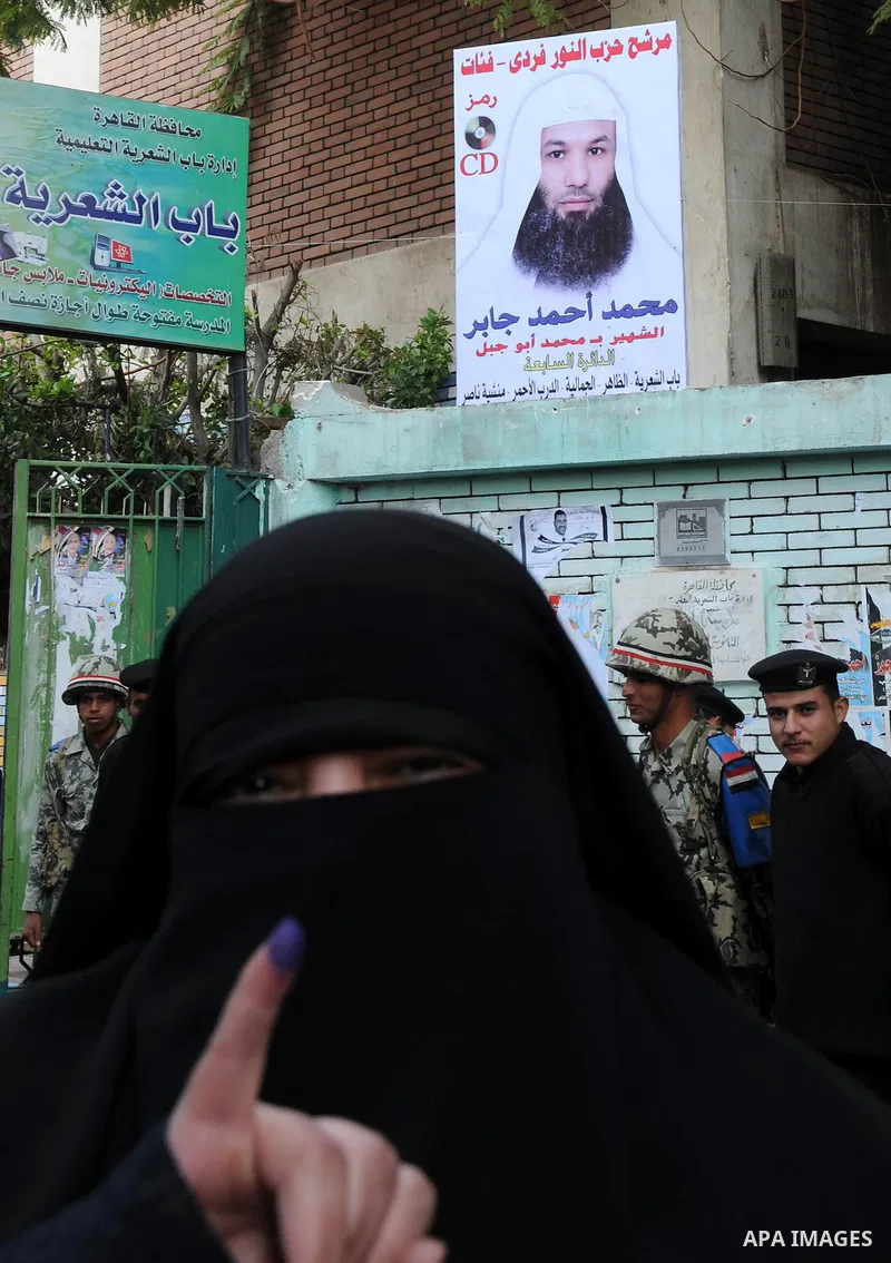 Egyptians cast their ballot at a parliamentary polling station in the run-off of the first round of voting in the Cairo neighbourhood of Bab El-Shaeria on December 5, 2011. Islamist candidates in Egypt looked to extend t...