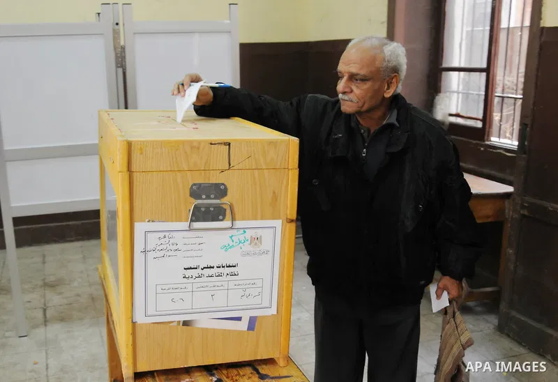 Egyptians cast their ballot at a parliamentary polling station in the run-off of the first round of voting in the Cairo neighbourhood of Bab El-Shaeria on December 5, 2011. Islamist candidates in Egypt looked to extend t...