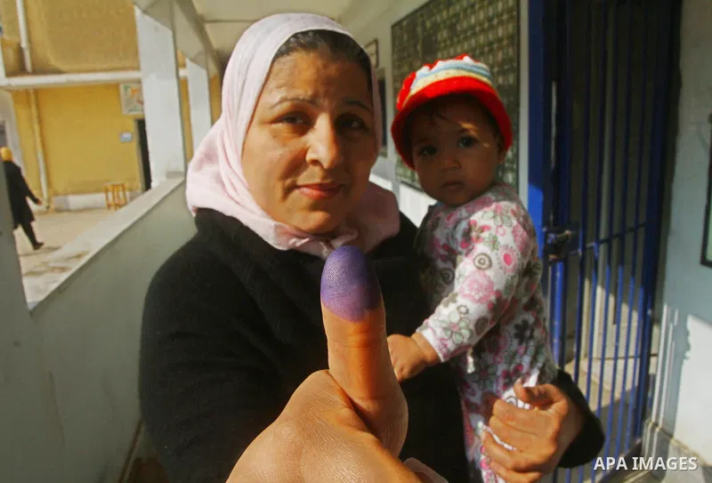 An Egyptian woman shows her ink-stained finger during the run-off of the first round of parliamentary voting in the Cairo neighbourhood of al-Manial on December 5, 2011. Islamist candidates in Egypt looked to extend thei...