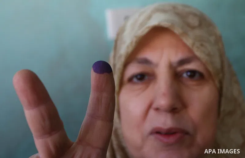 An Egyptian woman shows her ink-stained finger during the run-off of the first round of parliamentary voting in the Cairo neighbourhood of al-Manial on December 5, 2011. Islamist candidates in Egypt looked to extend thei...