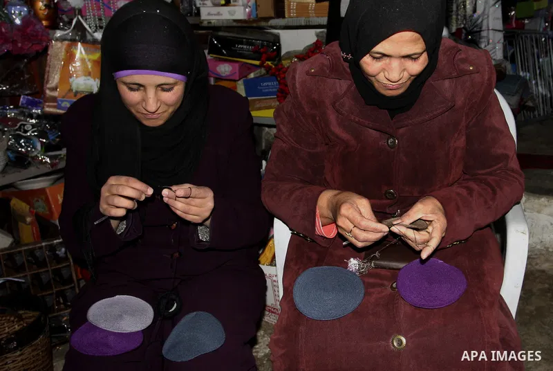 Palestinian women knit Kippas, traditional Jewish skullcaps, in the West Bank Village of Brukin near Nablus, Sunday, Dec. 05, 2011. The Palestinian women knit the Kippas in their West Bank village in order to sell them t...